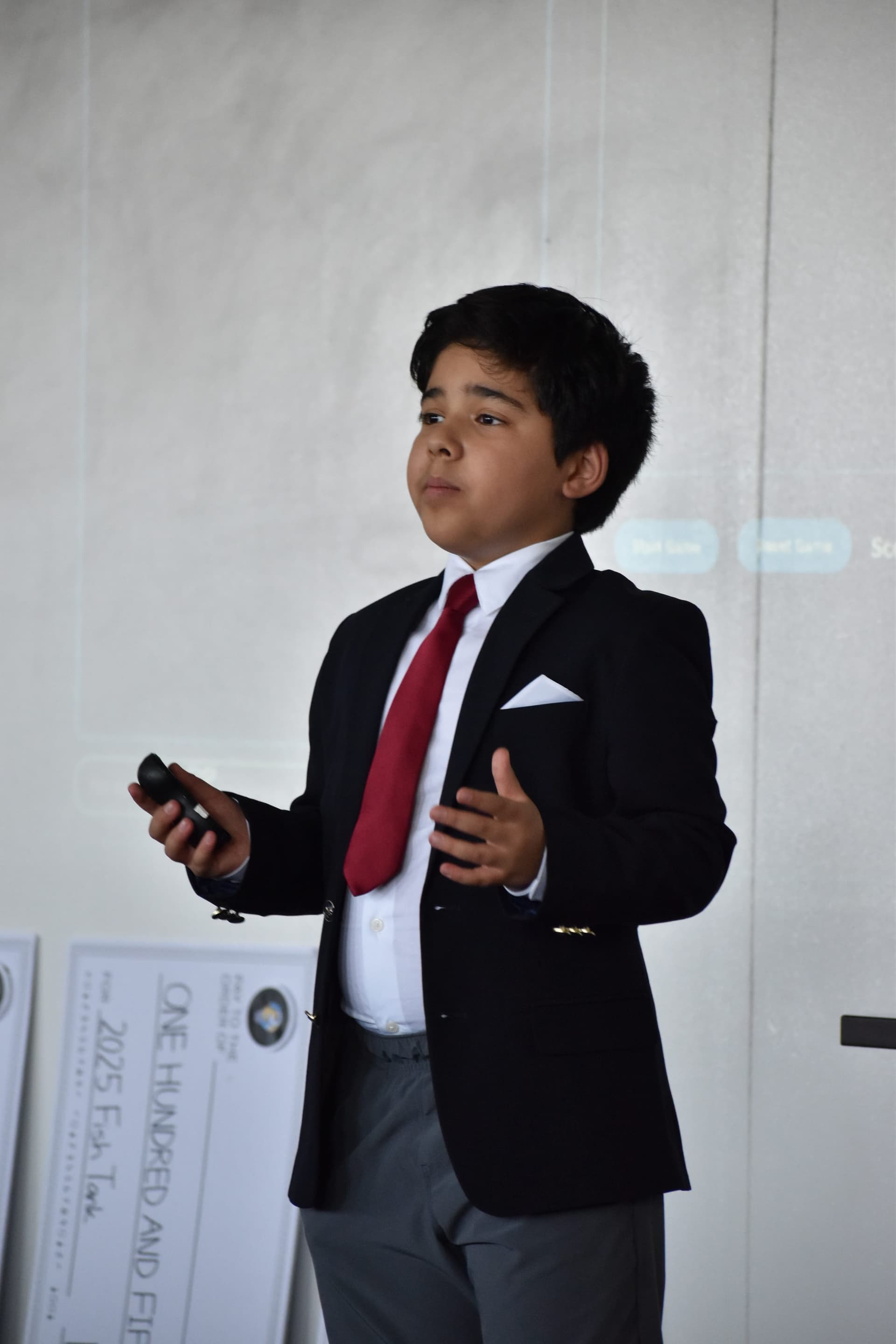 A student in a suit pitching his business at Fish Tank 2025