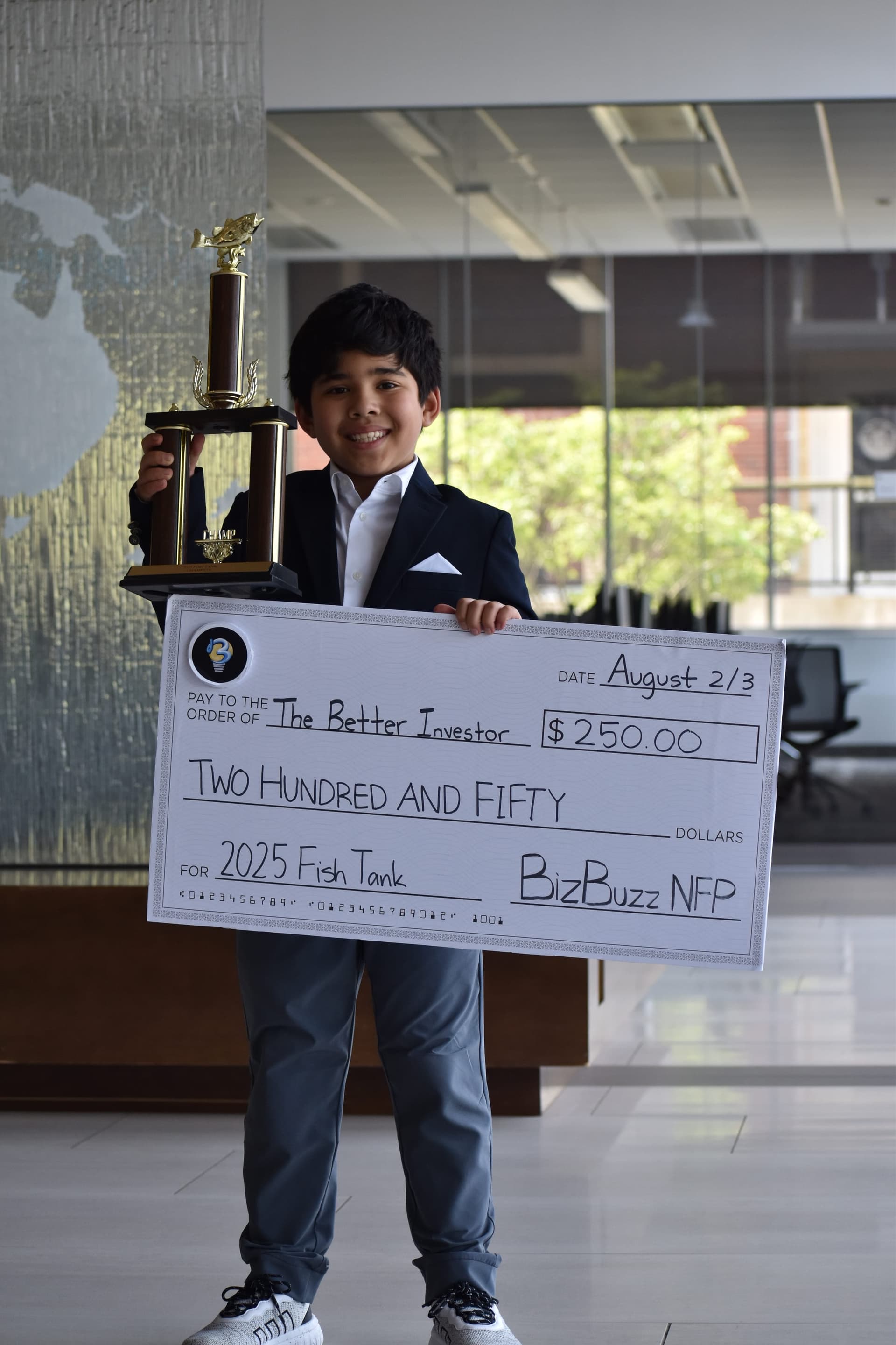 AbduRahman Yuldash holding the first-place trophy and check for The Better Investor