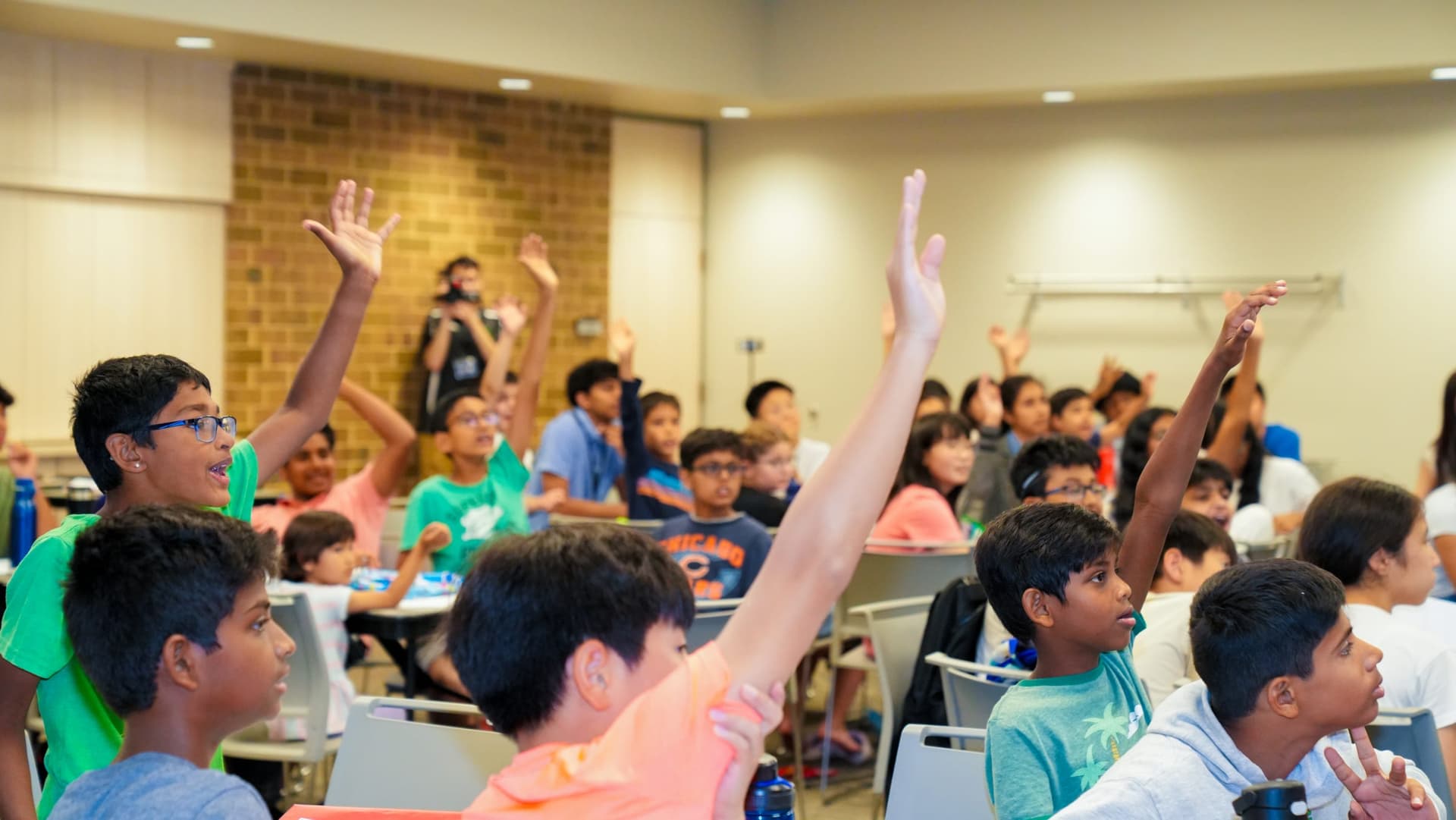 Campers raising their hands to answer a question